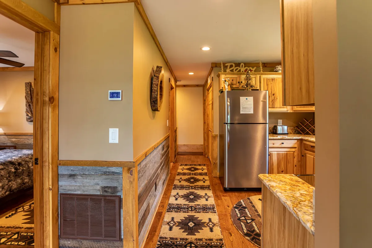 A beautifully designed kitchen with modern appliances, a textured wall, decorative accents, and a cozy rug. The space is perfect for cooking, dining, and entertaining, offering a glimpse of daily life and shared experiences in the home.